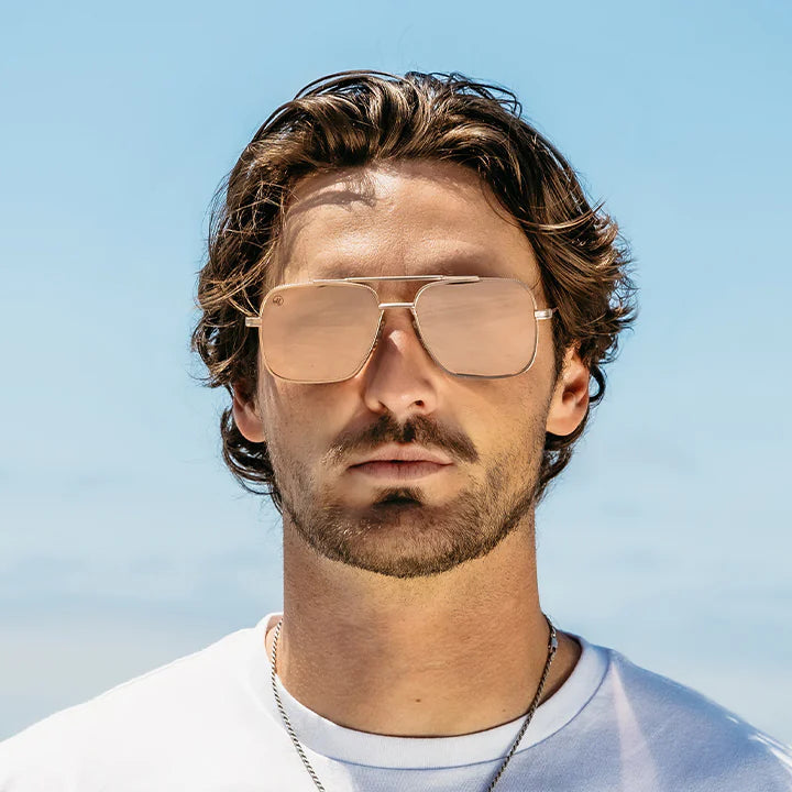 Man wearing sunglasses with a clear blue sky background