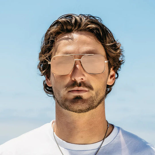 Man wearing sunglasses with a clear blue sky background