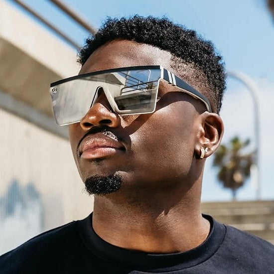 Man wearing futuristic sunglasses with a cityscape background