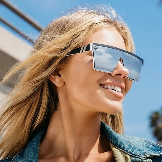 Woman wearing sunglasses with palm trees and a clear sky in the background