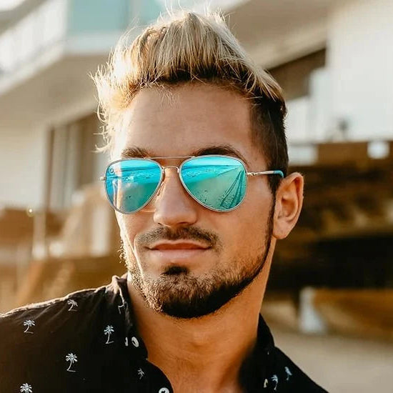 Man wearing blue reflective sunglasses with a blurred background